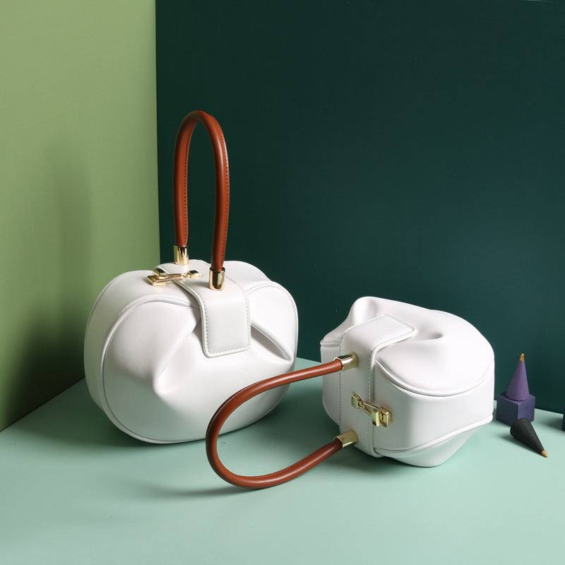 Cowhide Dumpling Tote Bag in white leather with curved soft shape, brown handles and buckle closure