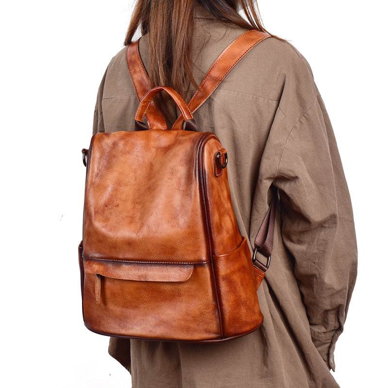 Cowhide Travel Backpack in soft brown leather with a rubbed vintage finish, front pocket and rigid grab handle