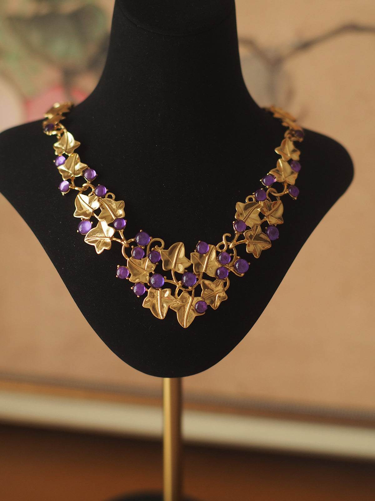 Grape Cluster Gold-Plated Necklace with gold-toned leaf links and clustered purple faceted stones