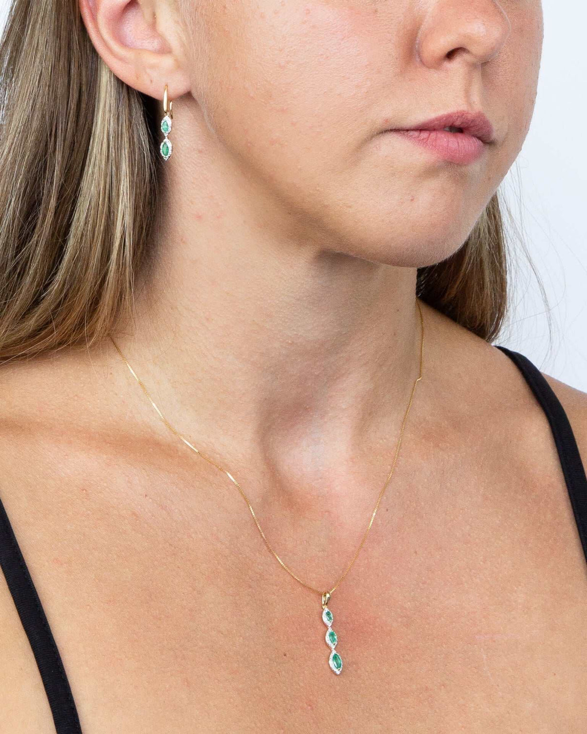 Marquise pendant in yellow gold with three turquoise stones and diamond surrounds, worn on a fine chain