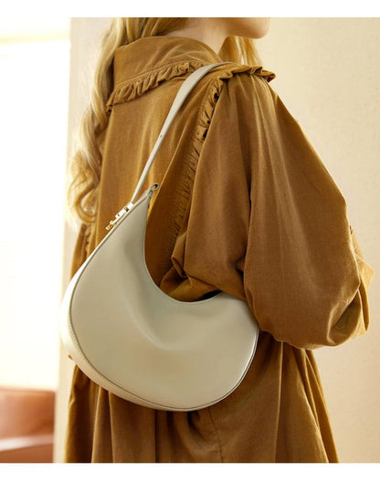 Cowhide Crossbody Bag in pale grey-white leather with a smooth curved shape and slim shoulder strap
