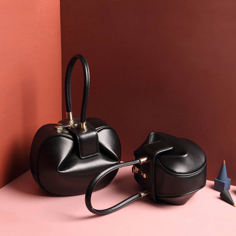 Cowhide Dumpling Tote Bag in black leather with a curved dumpling shape, buckle closure and single handle