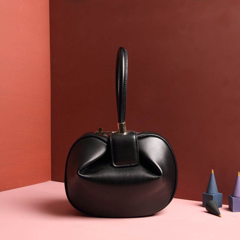 Cowhide Dumpling Tote Bag in black leather with a soft curved shape, buckle closure and single handle