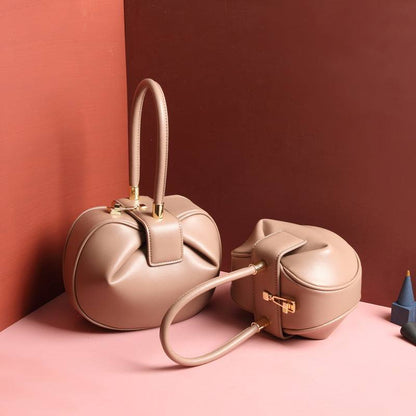 Cowhide Dumpling Tote Bag in blush pink leather with rounded slouchy shape, twin handles and buckle closure