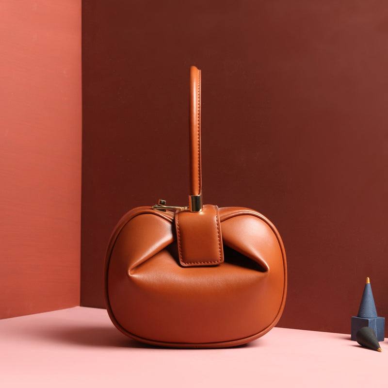 Cowhide Dumpling Tote Bag in caramel leather with a soft rounded shape, folded opening and buckle handle