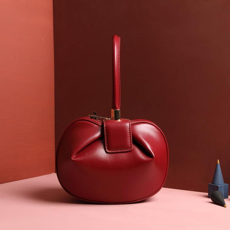 Cowhide Dumpling Tote Bag in deep red leather with curved slouchy shape, buckle closure and single handle