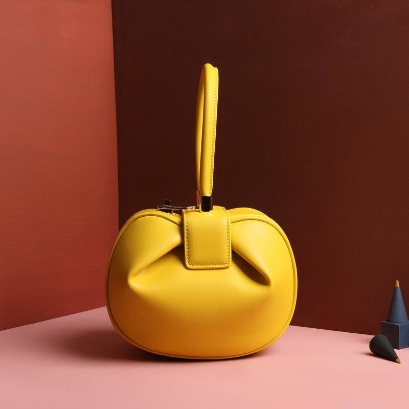 Cowhide Dumpling Tote Bag in bright yellow leather with a soft rounded shape, buckle closure and single handle