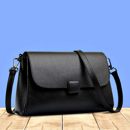 Cowhide Shoulder Bag in black textured leather with a soft shape, flap closure, and adjustable strap