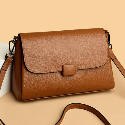 Cowhide Shoulder Bag in caramel brown leather with a plain pebbled finish, flap closure and adjustable strap