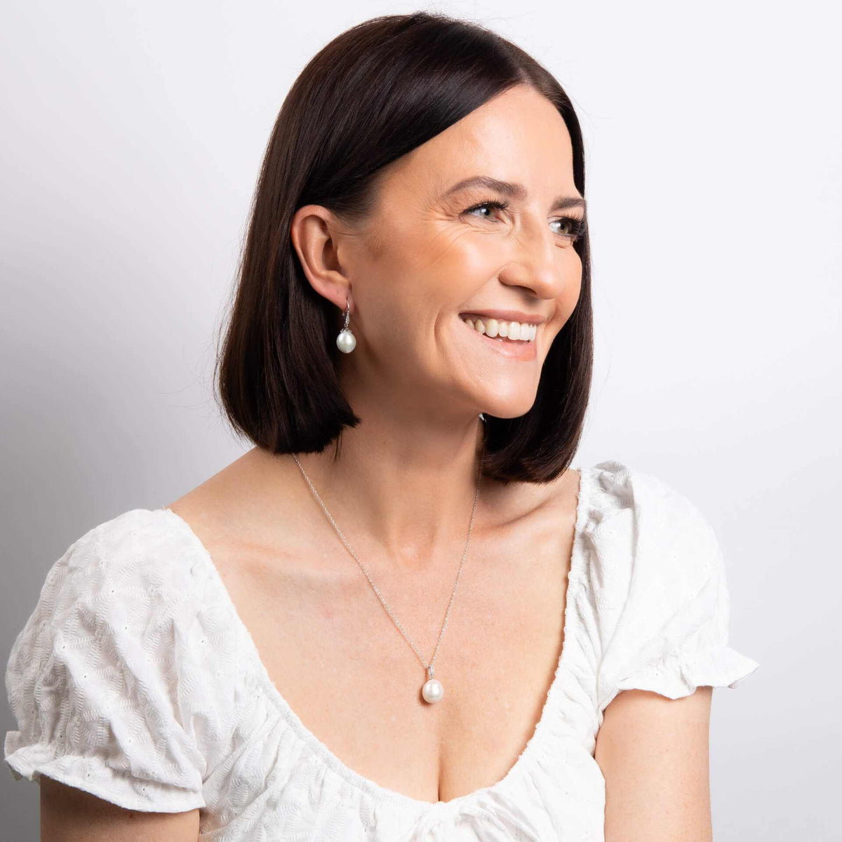 Elements Gold white gold drop earrings with irregular white pearls, worn as elegant pearl jewellery