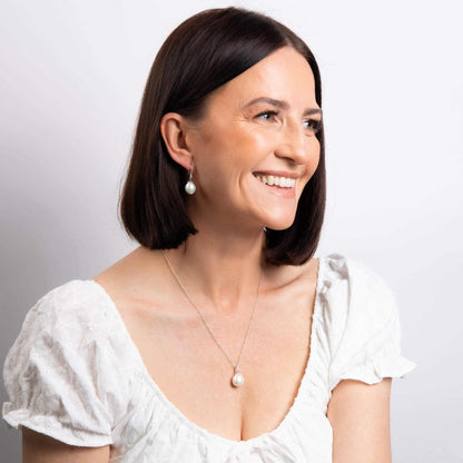 Elements Gold white gold drop earrings with irregular white pearls, worn as elegant pearl jewellery