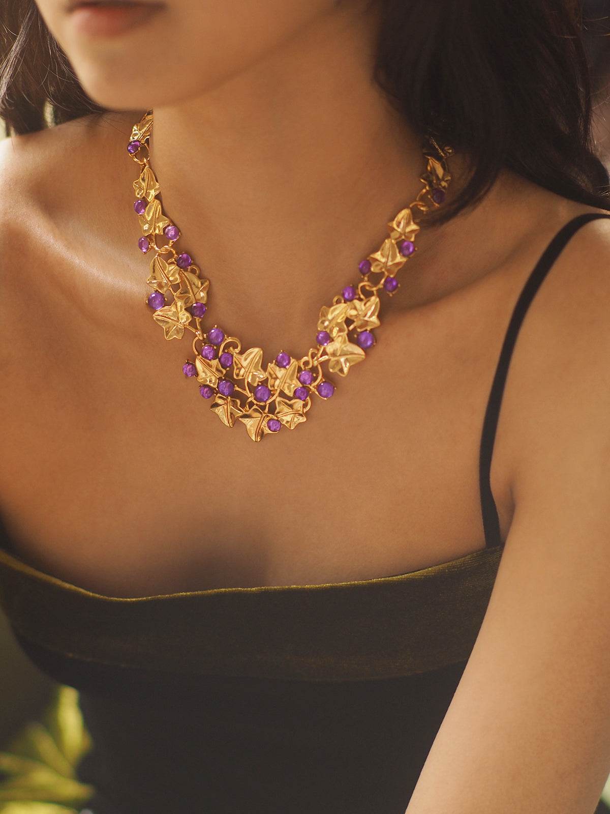 Grape Cluster Gold-Plated Necklace with gold-tone floral links and purple faceted stones in a layered cluster design