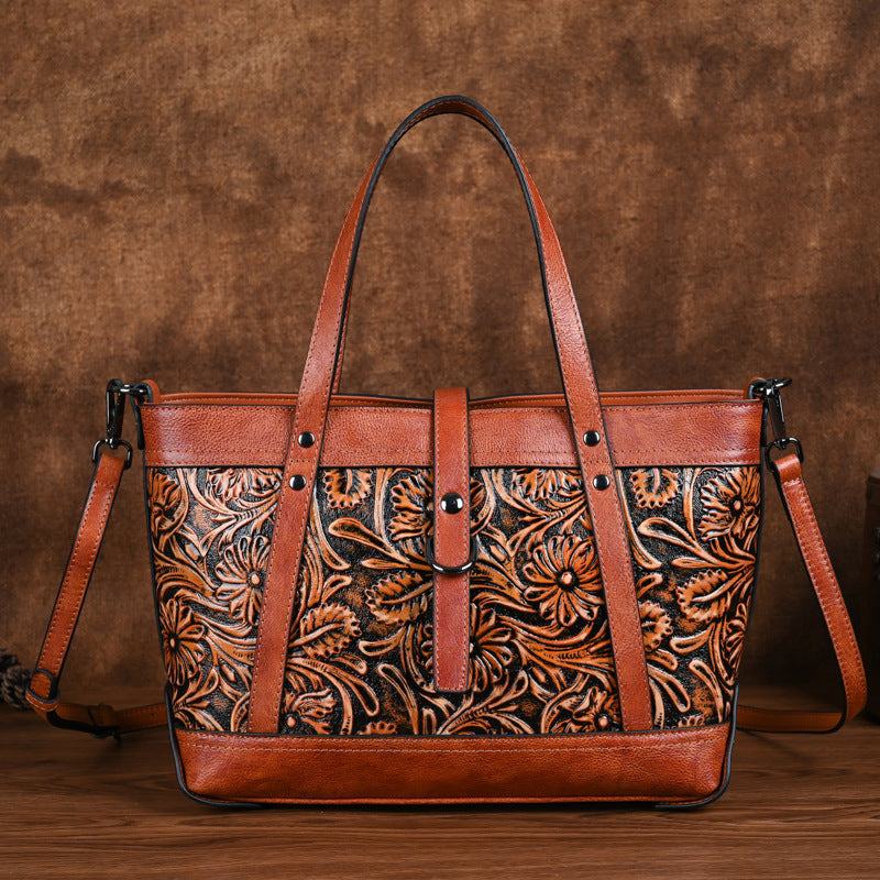 Hand-Carved Cowhide Crossbody Bag in brown leather with floral carved panel, contrast trim and shoulder strap