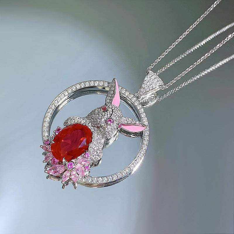 Rabbit Pendant Necklace with silver-tone rabbit, faceted deep red stone, pink accents, and crystal circular pendant