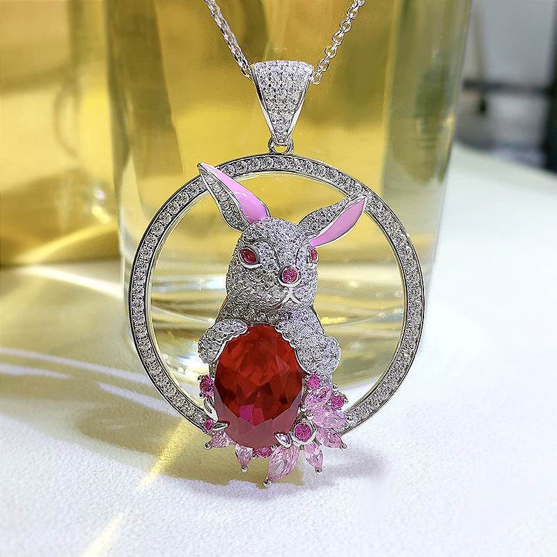 Rabbit Pendant Necklace with silver-tone rabbit, faceted deep red stone, pink accents and crystal-studded circular pendant