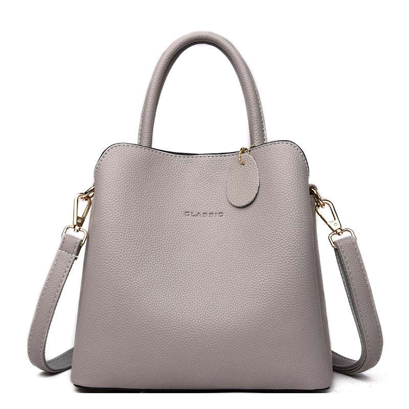 Vegan Leather Bucket Bag in taupe litchi-grain PU with a structured square shape, soft handle and shoulder strap